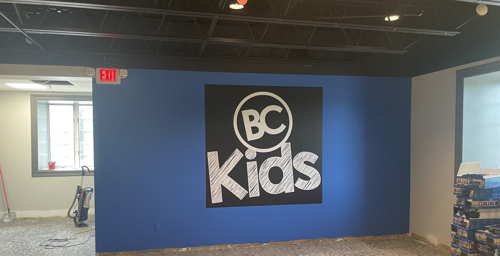 BC Kids ministry wall graphic on a blue feature wall