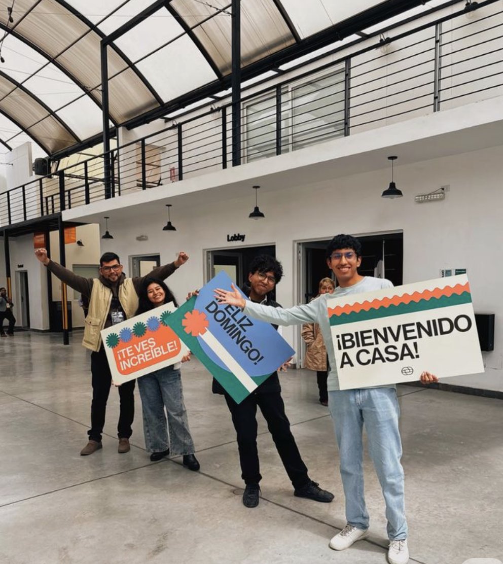 Welcome team holding hand-printed welcome signs in Spanish